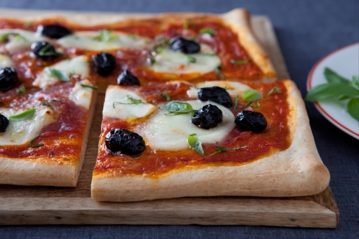 Recette de pizza au salami, olives noires et basilic facile et rapide